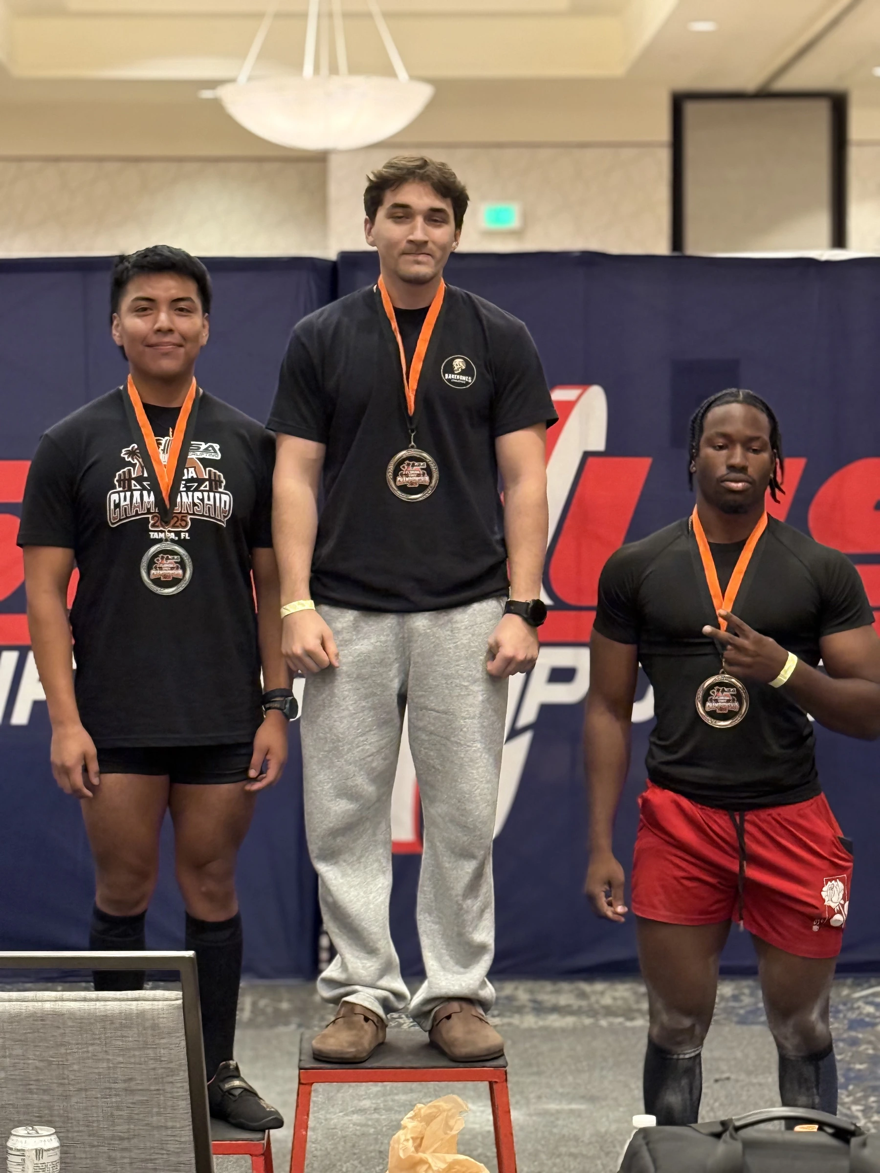 Three Forte Strength lifters on the podium with medals after a USA Powerlifting meet