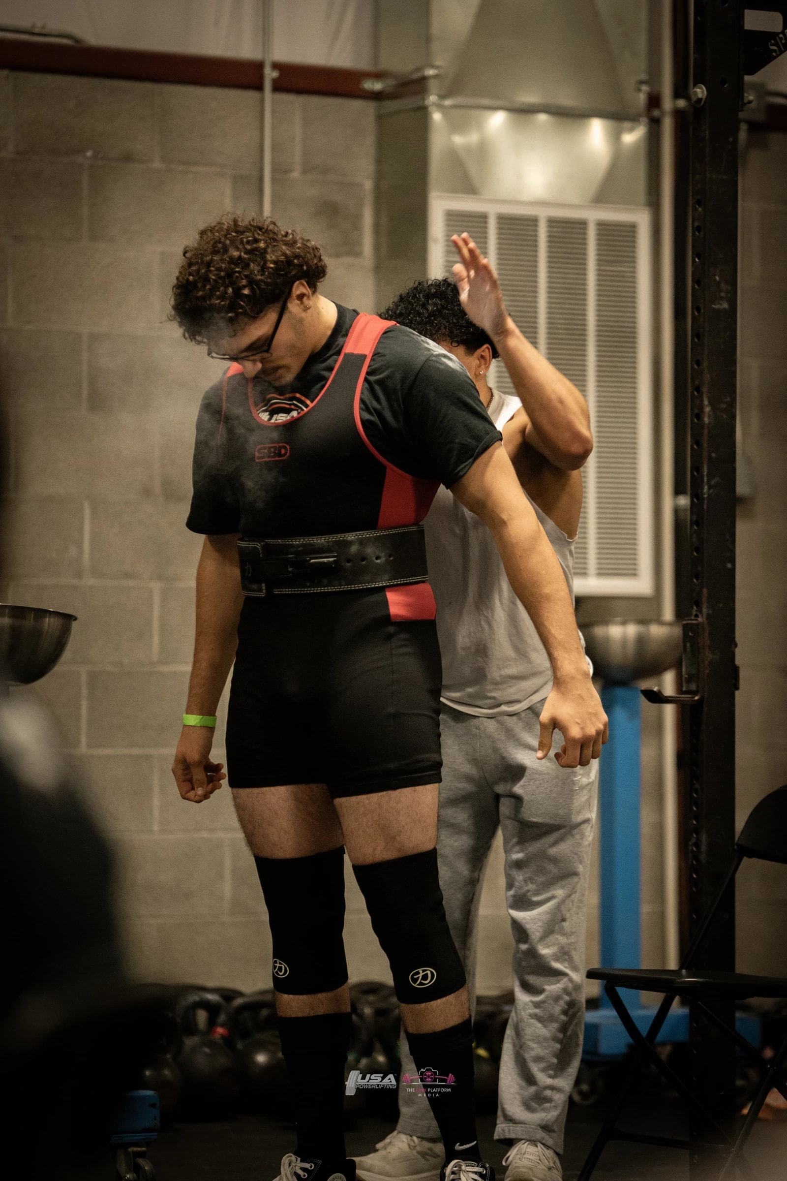 A Forte Strength lifter in a singlet getting ready in the warm-up room before an attempt